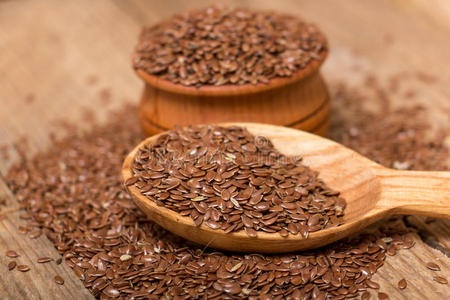 橙色,核桃和亚麻籽,浅灰色的背景亚麻籽勺亚麻籽的花朵鲜花和亚麻籽