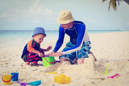 父子俩在海滩上建沙堡