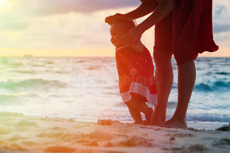 母亲和小女儿在沙滩上散步
