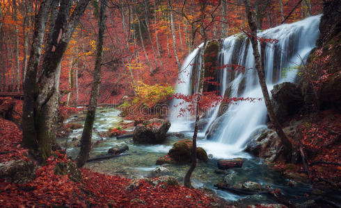 美丽的瀑布在秋天的森林里，在克里米亚山脉的阳光下