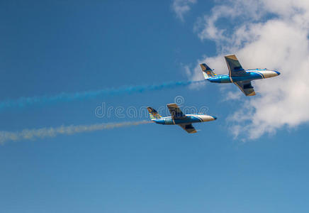 天空中的飞机带着五颜六色的烟雾照片