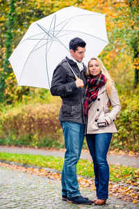一对夫妇享受秋天的日子，尽管下雨，散步