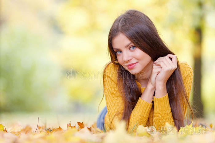 黑发女人躺在秋天的公园里