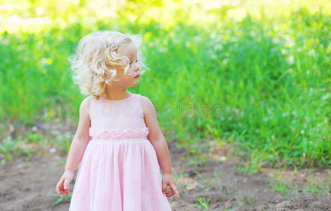 可爱的小女孩，卷发，穿着粉红色的连衣裙