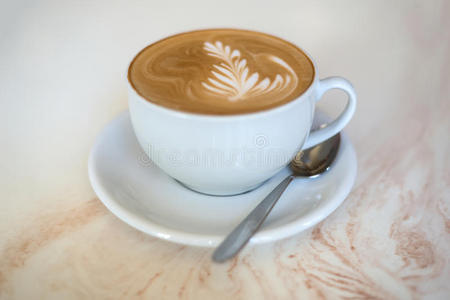 咖啡或拿铁咖啡在一个白色的杯子在一个轻的背景