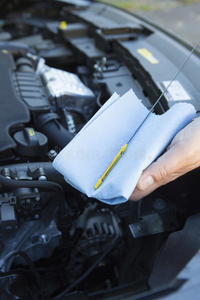 人体特写检查汽车发动机油位在试纸上