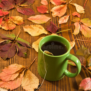 秋叶和茶杯在木头背景上