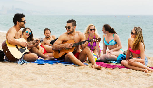 在海滩上带吉他的成年人