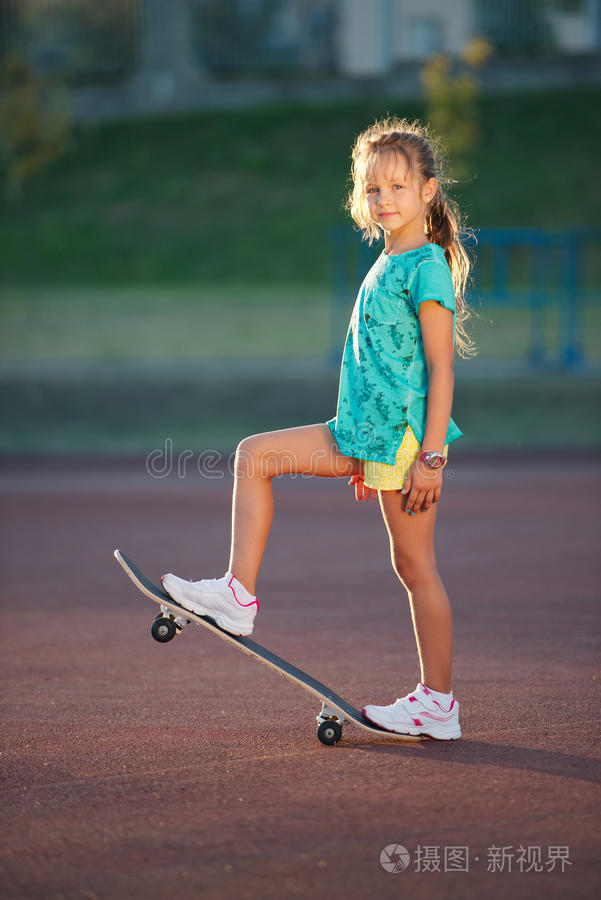 可爱的小女孩在户外玩滑板