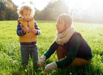 一个金发小男孩和他妈妈在外面玩