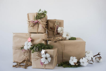圣诞礼品盒，有鲜花和装饰物，生态棉，肉桂，云杉枝和黄麻绳汉克在白色背