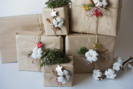 圣诞礼品盒，有鲜花和装饰物，生态棉，肉桂，云杉枝和黄麻绳汉克在白色背