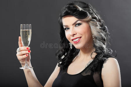 美丽的年轻女人用一杯香槟庆祝