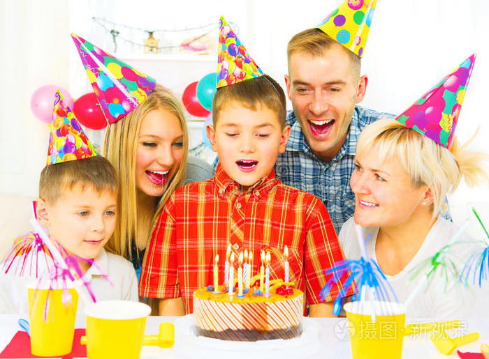 生日。 小男孩在生日蛋糕上吹蜡烛