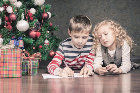 男孩和女孩躺在圣诞树下的地板上