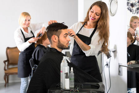 有吸引力的理发师在男人身上理发