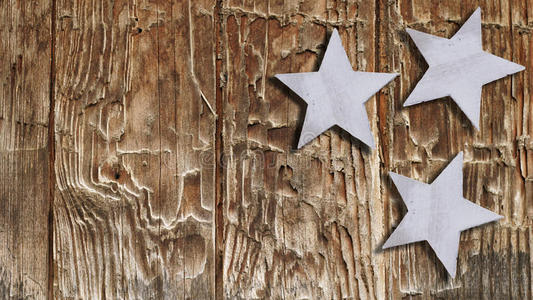 圣诞星星挂在质朴的木制背景上