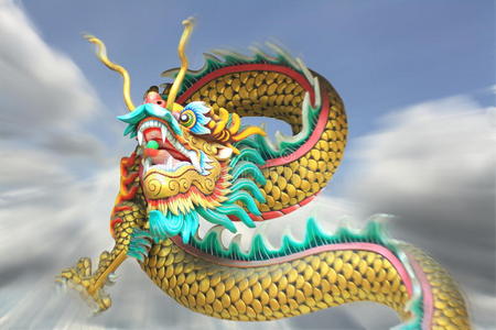 御龙在天战队名动作变焦模糊了中国龙雕像在天空中飞翔.照片