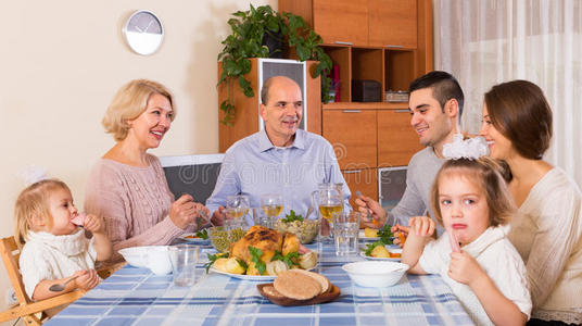 一家人坐在桌子旁吃晚饭
