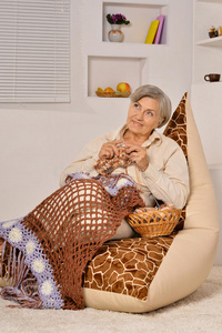 老年妇女坐着编织
