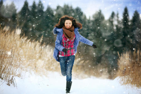 黑发女孩在雪林里跑步