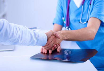 医生和病人握手,坐着照片