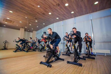 一群健身房的人在机器上，在课堂上骑自行车