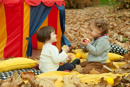 孩子们在公园里玩，吃苹果。