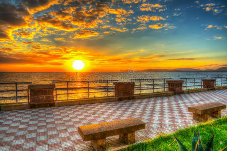 日落时阿尔盖罗海滨的长凳