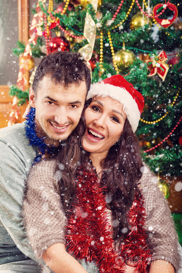 圣诞夫妇快乐地微笑着享受假期和雪