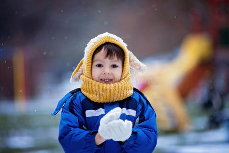 可爱的小男孩，在公园操场上玩雪