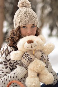 可爱，漂亮，漂亮的女孩拥抱一只毛茸茸的，白色的，米色的熊