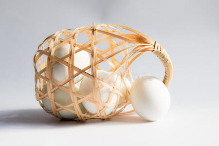 鸡蛋在篮子柳条在白色背景，鸭蛋