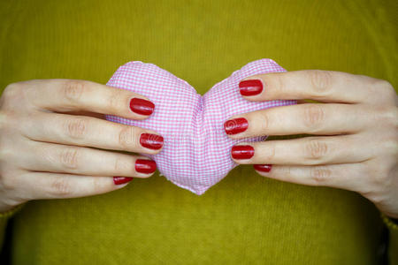 特写在女人手里的粉红色心脏上