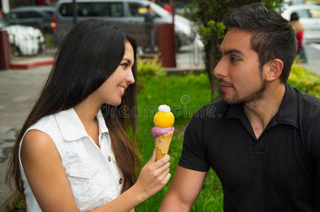 可爱的西班牙夫妇分享冰淇淋筒和