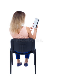 女人坐在椅子上看屏幕的背面