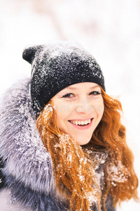 美丽的女人在冬天的雪天在树林里玩得很开心