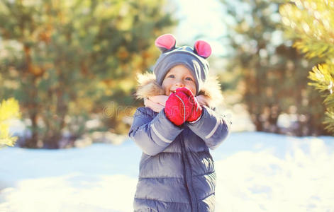 可爱的小孩子在阳光明媚的冬天玩走路照片
