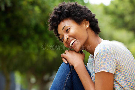 开朗的非洲年轻女人坐在户外
