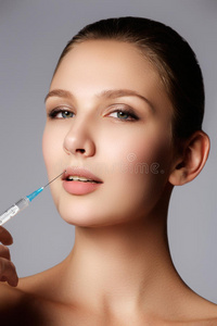 美女的特写镜头在她的嘴唇里注射. 丰满的嘴唇照片