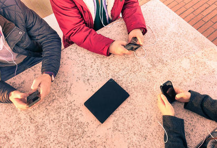 一群年轻的朋友和智能手机一起玩得很开心照片