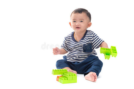 亚洲宝宝正在玩白色的塑料建筑玩具