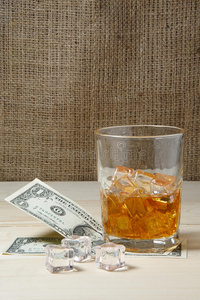 美元和一杯加冰的威士忌