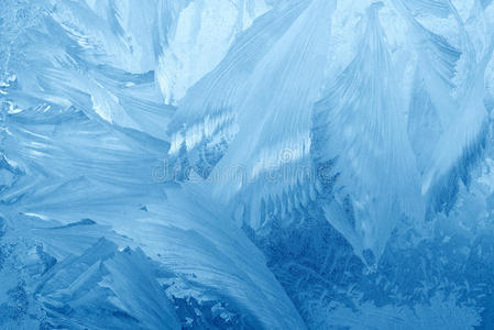 冬天窗户玻璃上的霜花图案。 磨砂玻璃质地。 蓝色