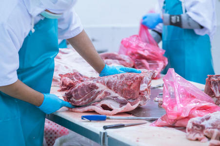 在工厂里切肉屠宰场的工人照片