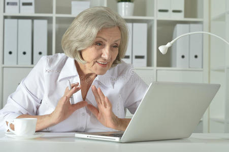 在笔记本电脑上工作的老妇人
