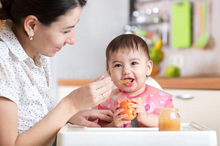 用勺子坐在椅子上吃健康食品的婴儿