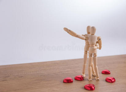 一个木娃娃男人在情人节在木地板上表现出爱和关系的行为。
