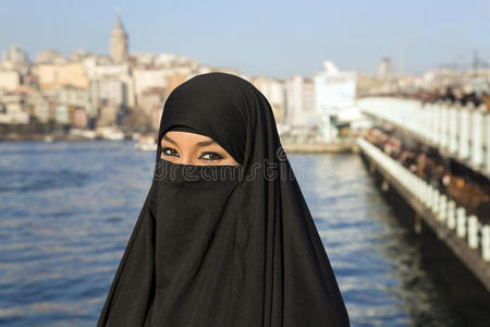 土耳其伊斯坦布尔大街上一位戴着黑色头巾的妇女照片