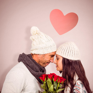 微笑夫妇鼻子对鼻子持有玫瑰花束的复合图像